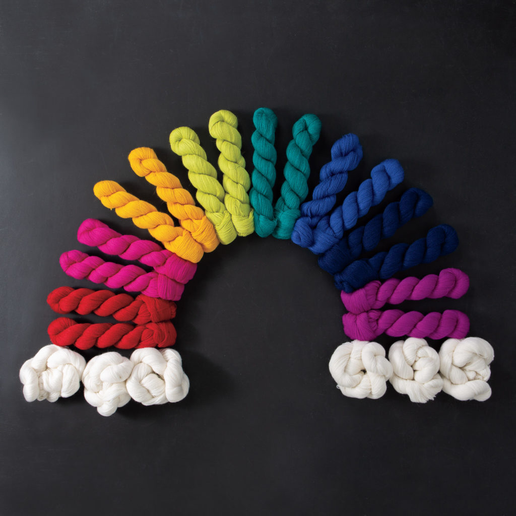9 colorways of Knit Picks Shimmer lace yarn in the shape of a rainbow.