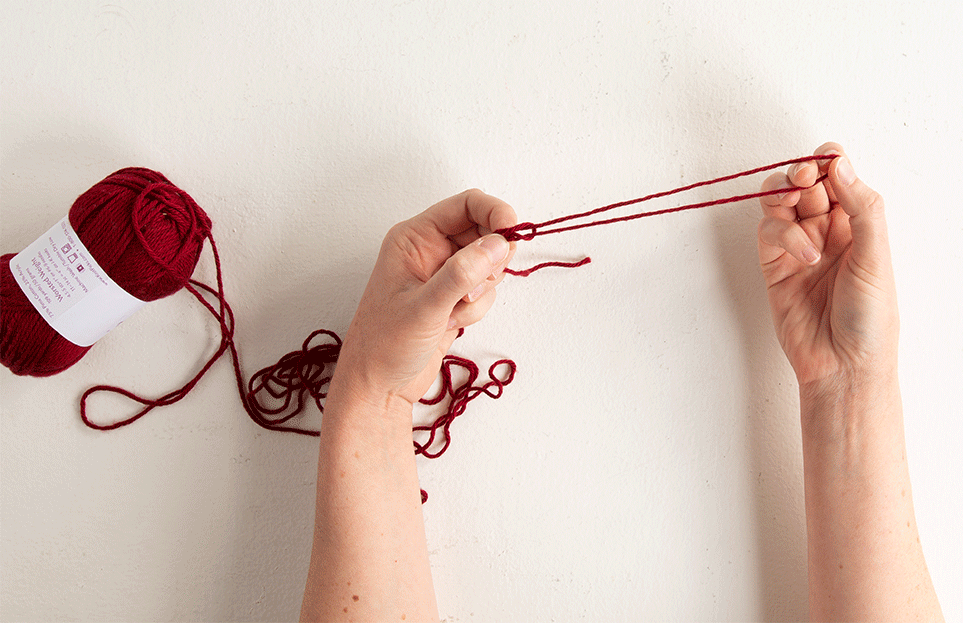 gif animation of triple-stranding step 2: pull yarn through slip knot