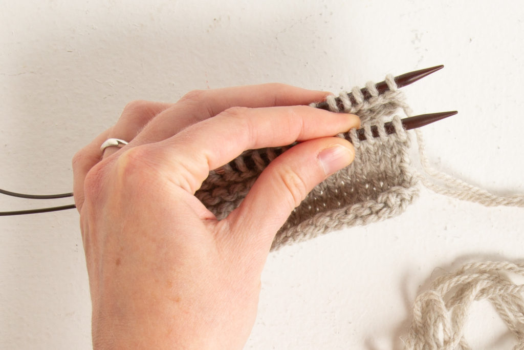 Two live rows of stockinette stitch, needles held parallel, ready for grafting