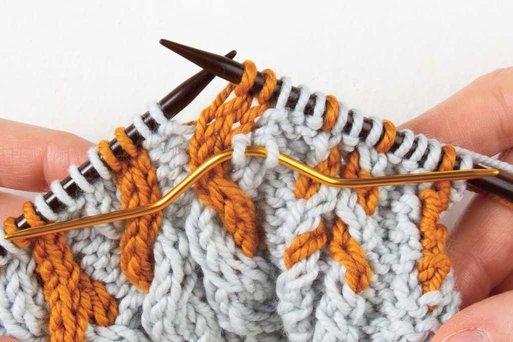 2-over-2 cable Left: 2 stitches knit with cable needle held to front