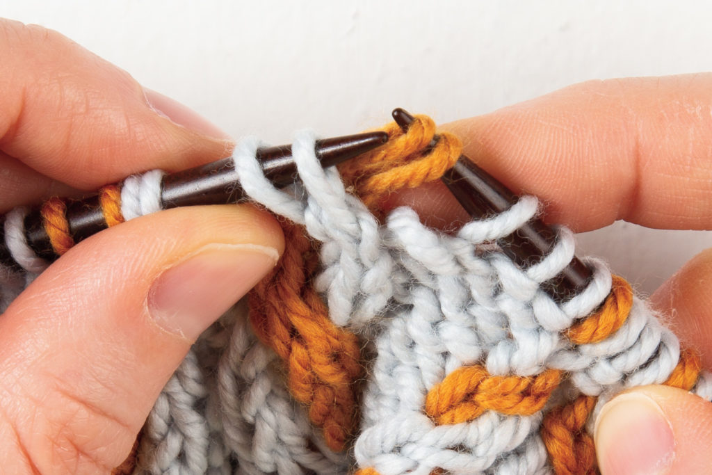 2-over-2 cable Left, without a cable needle: pull the 2 stitches on the right-hand needle to the right, behind the other 2 stitches on the left-hand needle